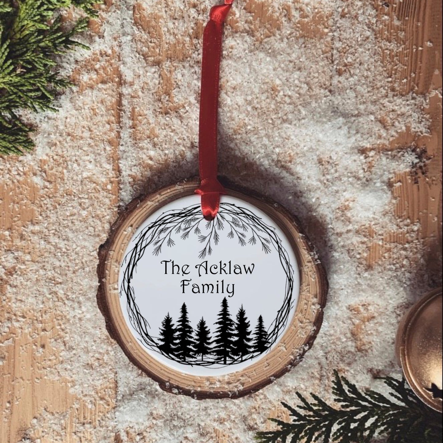 A simple black and white forest design with personalised family name in the centre. Ceramic tree ornament, hung with a red ribbon. 