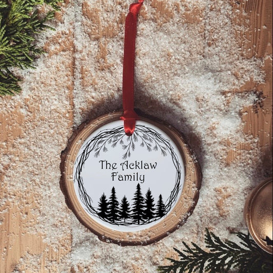 A simple black and white forest design with personalised family name in the centre. Ceramic tree ornament, hung with a red ribbon. 